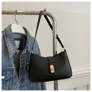 Detail of minimalist black hobo bag featuring a sleek gold metal twist lock buckle