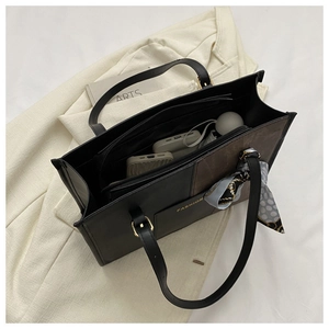 Interior detail of two-tone tote bag showing spacious compartments and zip pocket