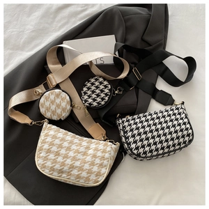Chic houndstooth crescent shoulder bags in black and beige with matching wide straps