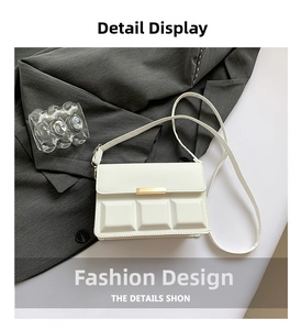 Detail of white square bag with embossed grid texture and golden metal buckle