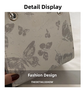 Detail shot of light gray crossbody bag featuring butterfly and star constellation patterns