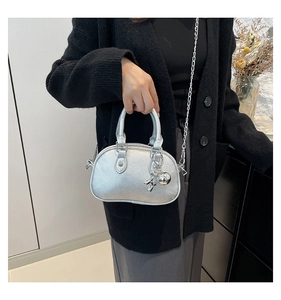 Détail du mini sac argenté en forme de coquillage avec chaîne et breloque lapin