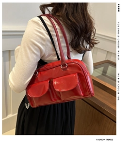 Model wearing a red patent leather Boston bag with double flap pockets in a lifestyle setting