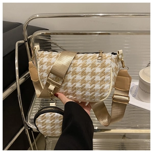 Detail of houndstooth half-moon shoulder bag with wide strap and round coin purse