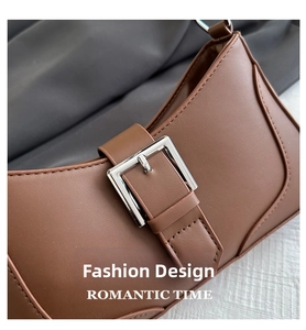 Detail of deep brown leather shoulder bag featuring a sleek silver rectangular buckle closure
