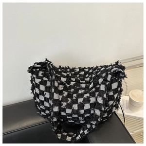 Detailed shot of frayed edges on a large capacity black and white checkerboard denim tote bag
