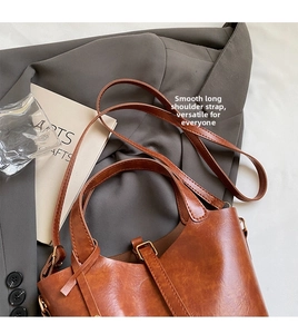 Détail du sac seau en cuir caramel avec bandoulières réglables et boucle polie
