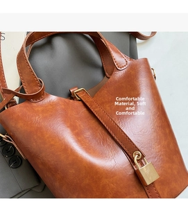 Détail d'un sac seau vintage en cuir marron avec texture souple et fermoir doré chic
