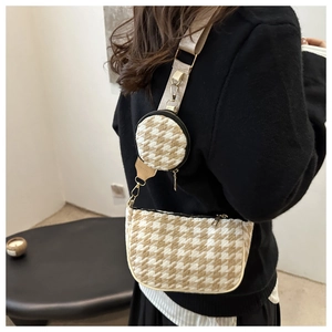 Detail of houndstooth crossbody bag with detachable round coin purse and wide strap