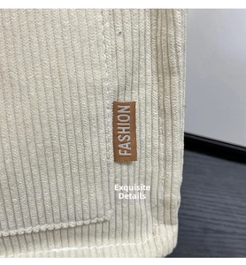 Detail of beige corduroy tote bag showing fine stitching and a brown Fashion label