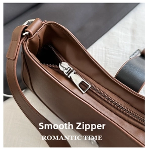 Macro view of silver metal zipper detail on brown vintage leather shoulder bag