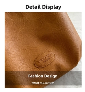Macro shot of brown pebble grain leather texture with a stitched embossed logo patch