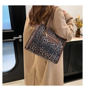 Rear view of a model wearing the leopard print tote bag with brown leather trim detailing