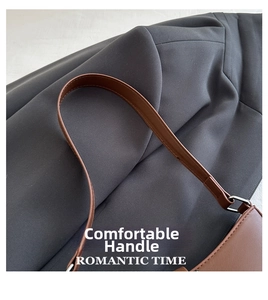 Detail of dark brown leather strap with silver metal ring on gray fabric background