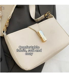 Detail of minimalist cream PU leather shoulder bag with gold rectangular metal buckle