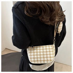 Detail of houndstooth crossbody bag with a detachable small round coin purse on the strap