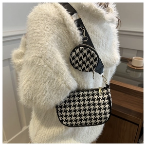Detail of houndstooth crossbody bag with wide strap and round coin purse on a model