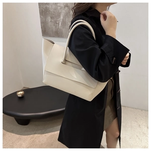 Off-white large leather tote bag worn by model, showing capacity and strap length