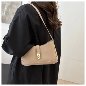 Detail of light beige PU leather shoulder bag with golden metallic twist lock buckle