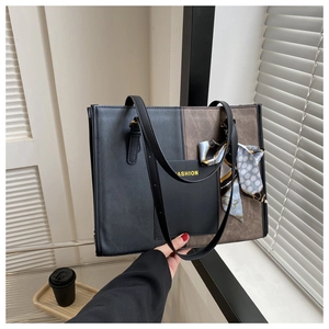 Detail view of contrast color tote bag with silk scarf and fashion logo on leather