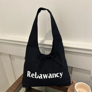 Minimalist black canvas tote bag with Rebawancy print and decorative bow detail