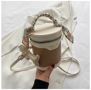 Detail of crocodile embossed cylindrical bag with silk scarf handle and dog charm