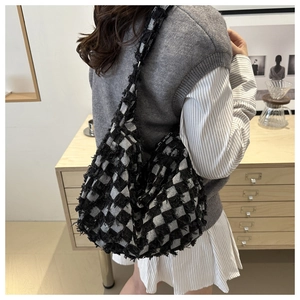 Close-up of hobo bag with frayed edges in black and white checkerboard pattern fabric