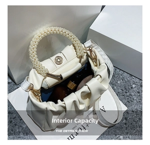 Detail view of the pearl bead handle and spacious interior of the cream dumpling bag