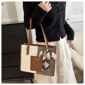 Detail of color-block tote bag with FASHION pocket and decorative silk scarf accent