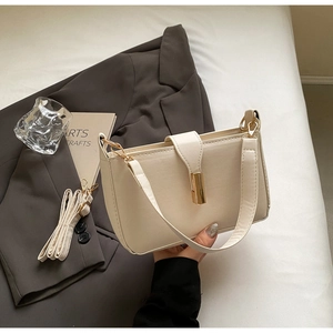 Detail view of cream PU leather square bag with gold lock and adjustable strap