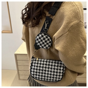 Detail of houndstooth half-moon bag with wide strap and round coin purse attachment