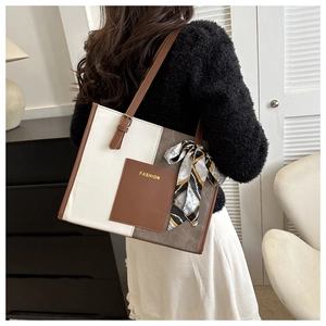 Detail of color-block tote bag with brown fashion pocket and decorative scarf