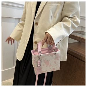 Detailed view of pink butterfly print on a mini tote bag with leather handles