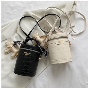 Detail of cylinder bucket bags with crocodile pattern, silk scarves and puppy charms
