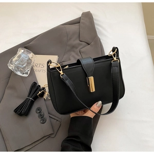 Detail of black rectangular shoulder bag with gold metal buckle and dual strap options