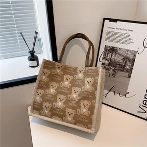 Detail of canvas tote bag with brown bear patterns and durable webbing handles