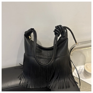 Primer plano del cuero granulado negro y los flecos largos en el bolso de hombro Hobo