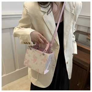 Detailed shot of pink butterfly print crossbody bag with dual handles and slim strap