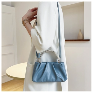 Detail of light blue pleated cloud bag with pearl handle and detachable shoulder strap
