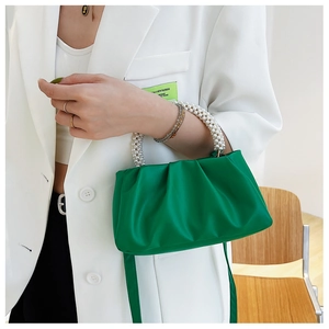 Detail of bright green pleated cloud bag with double white pearl beaded handles and satin sheen