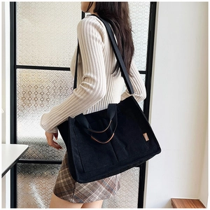 Large black corduroy tote bag with leather handles and fashion tag for women