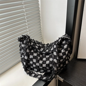 Modern black and white checkered tote bag with distressed edges and canvas texture