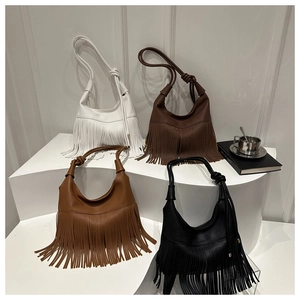 Detalle de bolsos tote grandes con flecos en colores blanco, marrón y negro para mujer