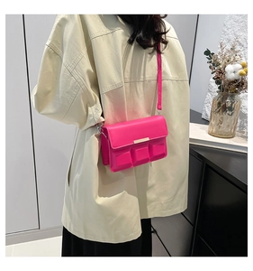 Detail showing the 3D chocolate texture and gold bar accent on the rose pink crossbody bag