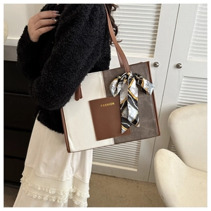 Detail of color-block tote bag featuring silk scarf handle and Fashion pocket label