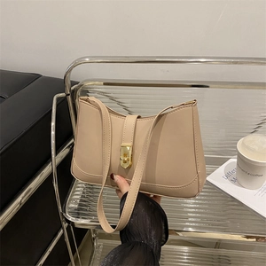 Minimalist beige underarm bag with metal twist lock and slim shoulder strap