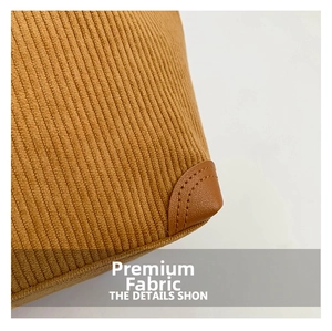 Detail of brown corduroy fabric with leather reinforced corners and neat stitching