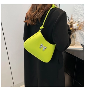 Détail du sac à bandoulière vert citron avec nœud argenté et sangle à nœuds design