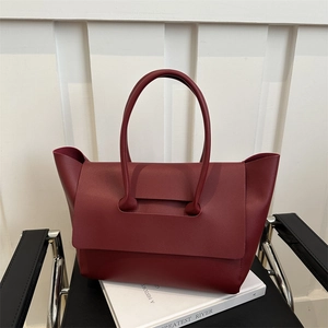 Minimalist large burgundy leather tote bag displayed on a modern chair for women