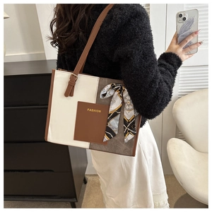 Detail view of the tricolor leather tote bag with printed silk scarf and gold lettering